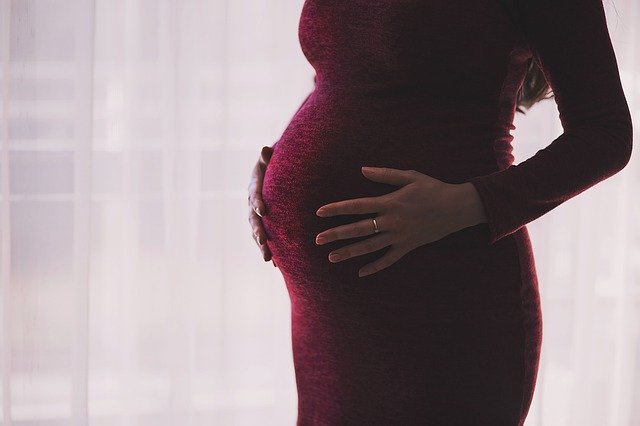 žena v upnutějších těhotenských šatech
